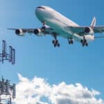 An airplane is taking off alongside a 5G tower