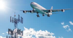 An airplane is taking off alongside a 5G tower